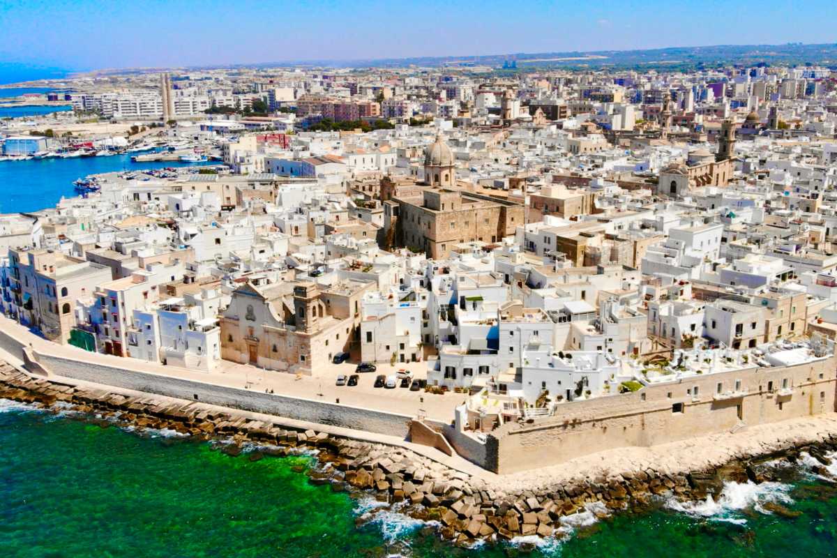 Panorama di Monopoli con il mare cristallino e il centro storico, evidenziando le calette nascoste